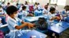 FILE - Students apply hand sanitiser while attending a class at the Viqarunnisa Noon School & College after the government has withdrawn restrictions on educational institutions following a decrease in the number of cases of COVID-19 in Dhaka, Bangladesh, Sept. 12, 2021. 