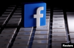 FILE - A 3-D-printed Facebook logo is seen placed on a keyboard in this illustration, March 25, 2020.