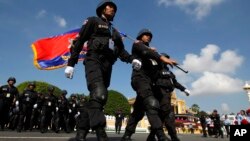 Cambodian military officers walk after attending a celebration marking the 10th anniversary King Norodom Sihamoni's coronation, in front of the Royal Palace, in Phnom Penh, Cambodia, Wednesday, Oct. 29, 2014.