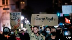 Demonstrators attend a 'Sit Out the Curfew' protest against the death of George Floyd who died on May 25 in Minneapolis while in police custody, along a street in Oakland, California, on June 3, 2020.