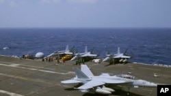 Pesawat jet AU US F-18 mendarat di kapal induk USS Carl Vinson (CVN 70) setelah patroli rutin di Laut China Selatan yang disengketakan, 3 Maret 2017. 