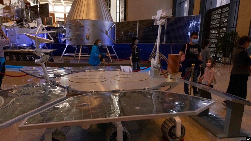 Visitors to an exhibition on China's space program look at a life size model of the Chinese Mars rover Zhurong, named after the Chinese god of fire, at the National Museum in Beijing on Thursday, May 6, 2021. (AP Photo/Ng Han Guan)