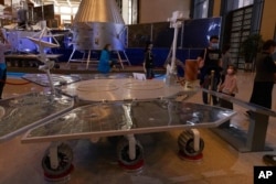 FILE - Visitors to a Chinese space exhibit look at a life-size model of the Chinese Mars rover Zhurong, named after the Chinese god of fire, at the National Museum in Beijing, May 6, 2021. China said May 15 that it had landed a rover on the Red Planet.