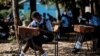 FILE - Students of St. Dominic Bukna Secondary School take their English test outside due to their overcrowded class room in Kisumu, Kenya, May 31, 2018.