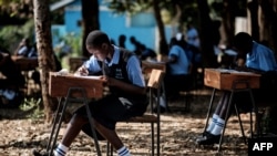 FILE - Students of St. Dominic Bukna Secondary School take their English test outside due to their overcrowded class room in Kisumu, Kenya, May 31, 2018.