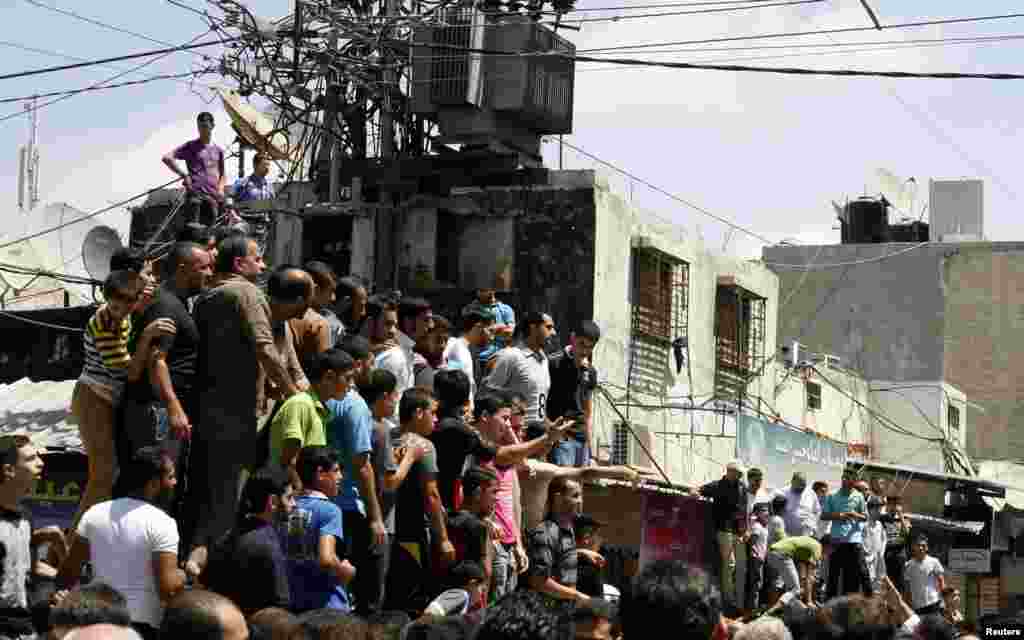 Palestinians watch as Hamas militants execute Palestinians suspected of collaborating with Israel in Gaza City, Aug. 22, 2014. 