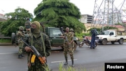 FILE - Army soldiers hold a checkpoint after the uprising that led to the toppling of President Alpha Conde in Kaloum neighbourhood of Conacry in Guinea, Sept. 6, 2021.