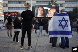 Warga Israel menyaksikan siaran pembebasan warga Israel Ofer Kalderon, 53 tahun, dan Yarden Bibas, 34 tahun, serta warga Amerika-Israel Keith Siegel, 65 tahun yang akan dibebaskan di Jalur Gaza, di Tel Aviv, Israel, 1 Februari 2025. (Foto AP/Oded Balilty)