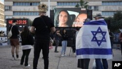 Israelíes observan una transmisión de la liberación de prisioneros y el estadounidense-israelí Keith Siegel, de 65 años, como parte de un alto el fuego en la Franja de Gaza, en Tel Aviv, Israel, el sábado 1 de febrero de 2025.