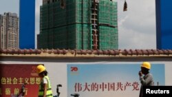 中国工人从云南省昆明市一处建筑工地旁走过。（2019年9月17日）