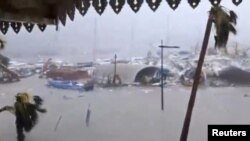 Half-submerged vehicles, boats and debris are seen in the flooded harbor as Hurricane Irma hits the French island territory of Saint Martin, Sept. 6, 2017, in this video grab made from footage taken from social media. (RCI GUADELOUPE/Handout via Reuters)