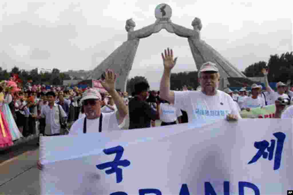 Pope Francis waves upon his arrival at Seoul Air Base, as South Korean President Park Geun-hye smiles, in Seongnam, Aug.14, 2014.