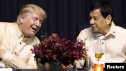 FILE - U.S. President Donald Trump speaks with Philippines President Rodrigo Duterte during the dinner marking ASEAN's 50th anniversary in Manila, Philippines, Nov. 12, 2017.