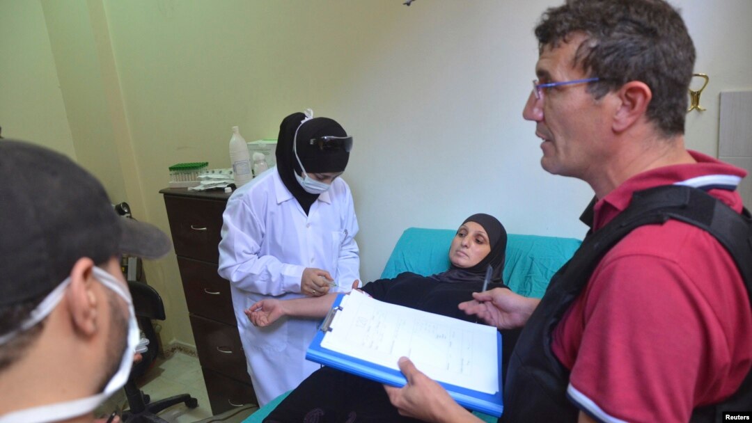 A UN chemical weapons expert meets a person affected by an apparent gas attack, at a hospital where she is being treated in Damascus' suburb of Zamalka, August 28, 2013.