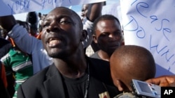 FILE - Vandalark Patricks protests outside Roberts International Airport. Patricks was arrested after he read a communique on behalf of a consortium of political parties and civil society organizations on February 21.