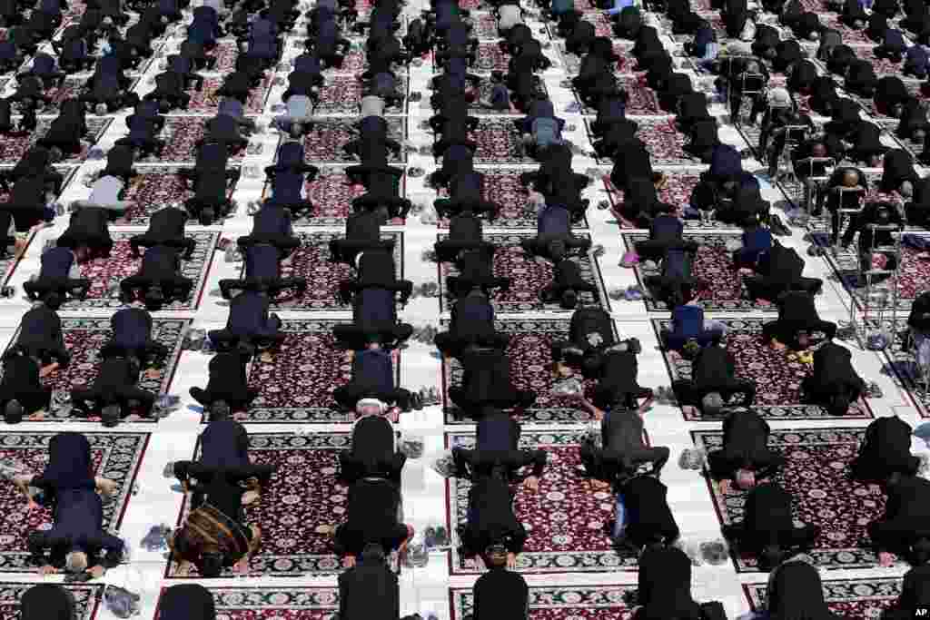 People attend the noon prayer during an annual mourning ceremony commemorating Ashoura, at the courtyard of the Saint Abdulazim shrine in Shahr-e-Ray, south of Tehran, Iran. 