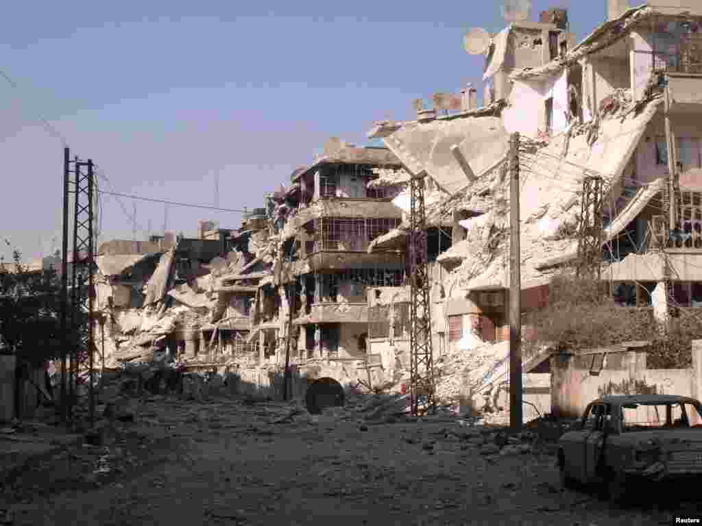A damaged car is parked near buildings destroyed during clashes between Syrian rebel fighters and government forces, in Al Qusour neighborhood, Homs, Syria, July 2, 2012. 