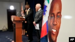 An image of Haitian President Jovenel Moïse, right, is displayed as Markenzy Lapointe, U.S. Attorney for the Southern District of Florida, speaks speaks during a news conference, Feb. 14, 2023, in Miami.