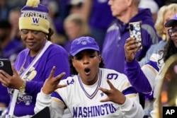 FILE - University of Washington fans cheer for their team before the college football national championship game in Houston, Texas on Jan. 8, 2024. (AP Photo/David J. Phillip)