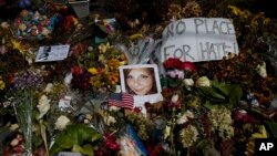 Una foto de Heather Heyer, quien fue asesinada durante una manifestación de nacionalistas blancos, es vista en el suelo, rodeada de flores, en un memorial en celebración de su vida en el teatro Paramount Theater en Charlottesville, Virginia, el miércoles, 16 de agosto de 2017.