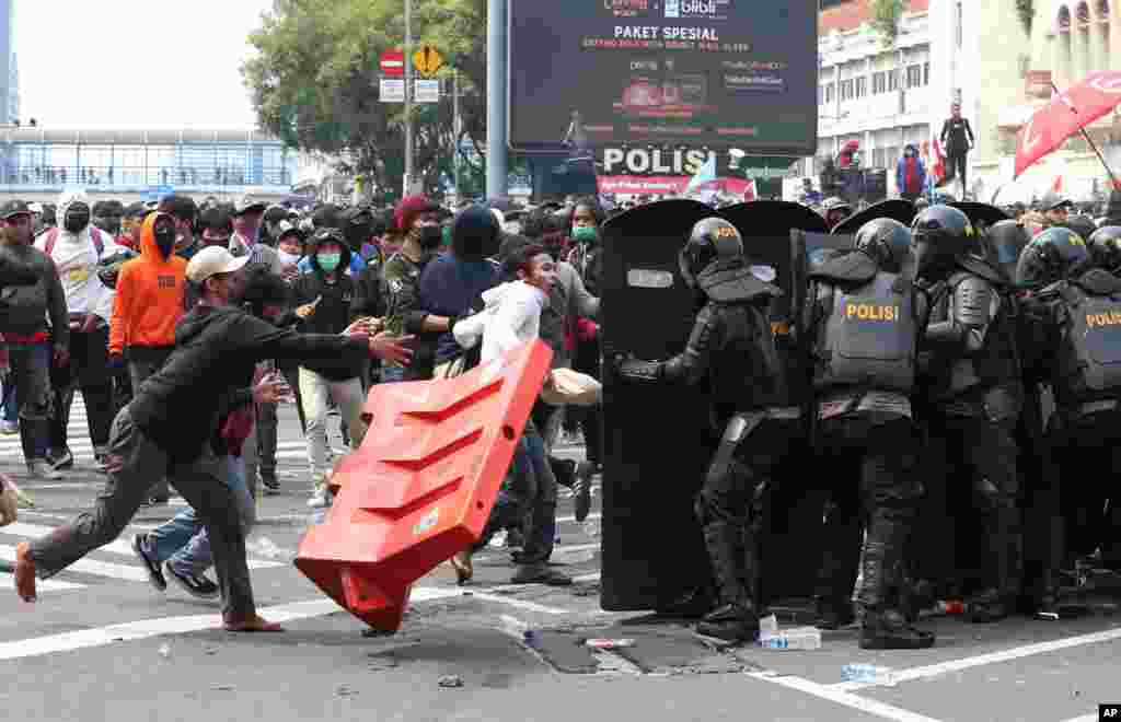 인도네시아 자카르타에서 정부가 추진하는 노동 법안을 반대하는 시위가 계속되는 가운데 대통령 궁으로 가는 길목을 봉쇄하고 있는 경찰과 시위대가 충돌했다. 
