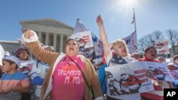 Para aktivis imigrasi berdemonstrasi di depan Mahkamah Agung AS di Washington, DC, mendukung keputusan eksekutif Presiden Brack Obama yang menghapuskan deportasi (18/3). (AP/J. Scott Applewhite)