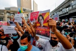 Myanmar nationals living in Thailand display pictures of detained Myanmar leader Aung San Suu Kyi during a protest against the military coup in Bangkok, Thailand, Feb. 10, 2021.