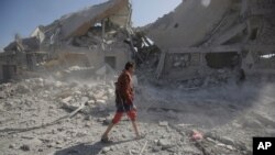 FILE - A Yemeni man walks amid the rubble of a Houthi-held detention center destroyed by Saudi-led airstrikes in Dhamar, Yemen, Sept. 1, 2019.