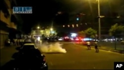 Syrian protesters run after tear gas canisters are thrown in al-Malaab street in Homs, 165 km (100 miles) north of Damascus, in this still image taken from video posted on a social media website, August 4, 2011 (Reuters cannot independently verify the con