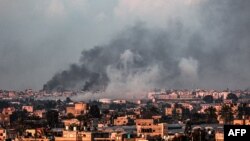 Gambar yang diambil dari Rafah menunjukkan asap mengepul di atas kota Khan Yunis di Jalur Gaza selatan selama pemboman Israel hari Minggu, 18 Februari 2024.