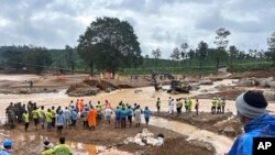 Para anggota tim evakuasi berdiri di dekat lokasi jembatan yang tersapu dalam bencana tanah longsor di Distrik Wayanand, negara bagian Kerala, India, pada 31 Juli 2024. (Foto: AP/Rafiq Maqbool)