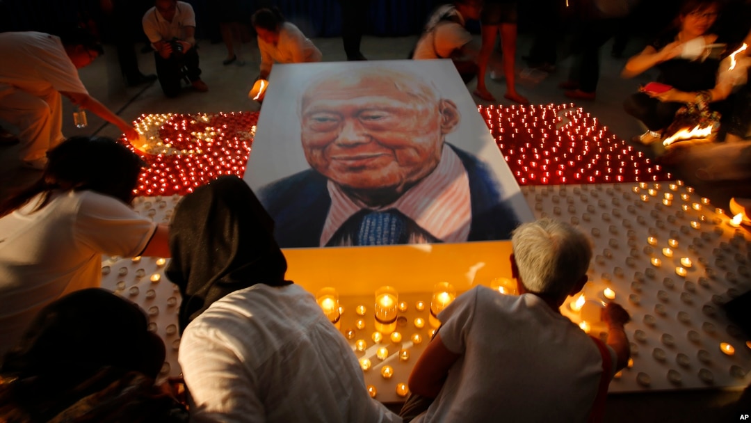 Warga di Singapura menyalakan lilin dekat foto mendiang Lee Kuan Yew sebagai penghormatan (27/3). (AP/Wong Maye-E)