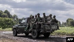 FILE — M23 soldiers leave Rumangabo camp after meeting EACRF officials, Jan. 6, 2023.