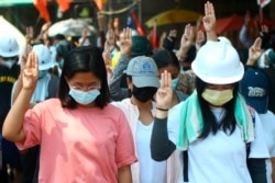 Anti-coup protesters flash the three-fingered symbol of resistance and bow in memory of those who died during recent security crackdowns in Yangon, Myanmar, March 5, 2021.