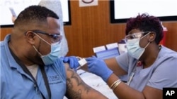 FILE - A UNC Medical Center employee receives his vaccination at the co-worker clinic in Chapel Hill, North Carolina, Feb. 2, 2021.