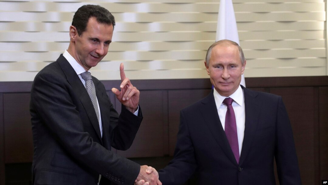 FILE - Russian President Vladimir Putin (R) shakes hands with Syrian President Bashar Assad in the Black Sea resort of Sochi, Russia, Nov. 20, 2017.