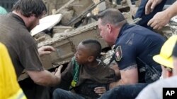 Seorang anak murid SD Plaza Towers berhasil diselamatkan dari reruntuhan bangunan setelah tornado melanda kota Moore, Oklahoma (20/5). 