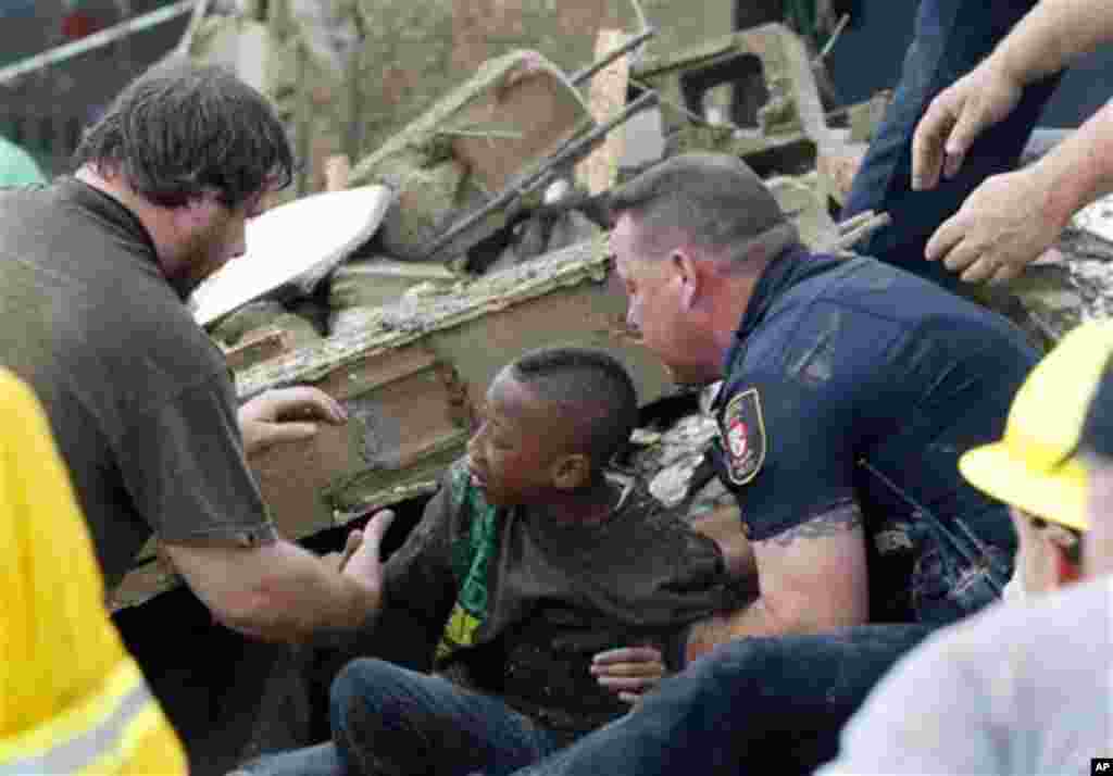 A boy is pulled from beneath a collapsed wall at the Plaza Towers Elementary School following a tornado in Moore, Okla., Monday, May 20, 2013.