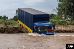 FILE —A truck stuck in the Shange river after the bridge on national road number 5 collapsed in the village of Sange, South Kivu province, eastern Democratic Republic of Congo, February 29, 2024.