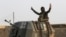 A member of Iraq's elite counterterrorism forces in a military convoy flashes a victory sign as forces advance toward Islamic State positions in the village of Tob Zawa, about 9 kilometers (5½ miles) from Mosul, Iraq, Oct. 25, 2016.