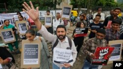 Indians hold placards and shout slogans during a protest against mob attacks in Ahmadabad, India, July 23, 2018. 