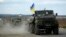 A Ukrainian military convoy moves ahead on the road near the eastern Ukrainian town of Slovyansk, Oct. 5, 2014. 