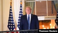 도널드 트럼프 미국 대통령이 지난 5일 월터 리드 군 병원에서 백악관으로 복귀한 직후 발코니에서 외부를 응시하고 있다.