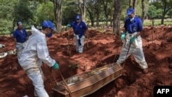 Workers bury a person believed to have died from COVID-19 at the Vila Formosa cemetery in the outskirts of Sao Paulo, Brazil, on March 31, 2020. 