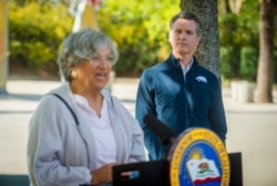 FILE - California Air Resources Board chair Mary Nichols, left, speaks as California Governor Gavin Newsom listens at a press conference in Sacramento, September 23, 2020.