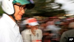 Cambodian opposition leader Sam Rainsy of the Cambodia National Rescue Party wearing a helmet arrives for a rally in Phnom Penh, file photo. 