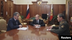 Russian President Vladimir Putin (C) speaks with newly appointed armed forces Chief-of-Staff Valery Gerasimov (R) and Defense Minister Sergei Shoigu during their meeting in Moscow's Kremlin, November 9, 2012. 