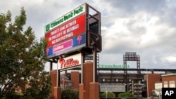 A sign outside the stadium advises that the baseball game between the Philadelphia Phillies and the Washington Nationals has been postponed, July 28, 2021, in Philadelphia. 