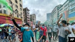 Para pengunjuk rasa berbaris selama protes flash mob di kotapraja Mingalar Taung Nyunt di Yangon, Myanmar, Minggu, 11 Juli 2021. (Foto: AP)