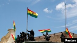 Oficiales de la policía colocan una bandera boliviana en una estación de policía durante una protesta contra el presidente de Bolivia, Evo Morales, en La Paz, Bolivia, el 9 de noviembre de 2019.